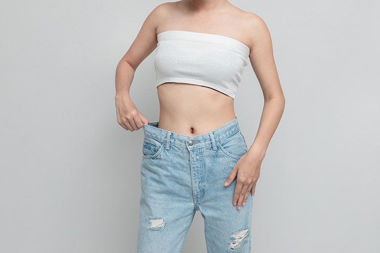 Woman in oversized jeans on a white background